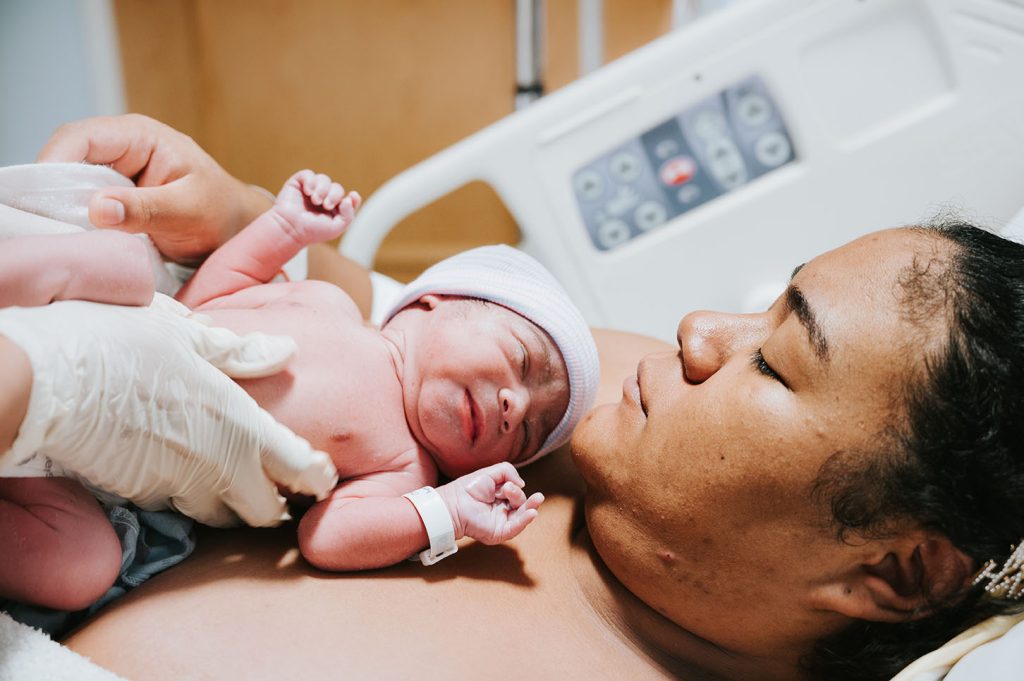 newborn baby being placed on mother's chest
